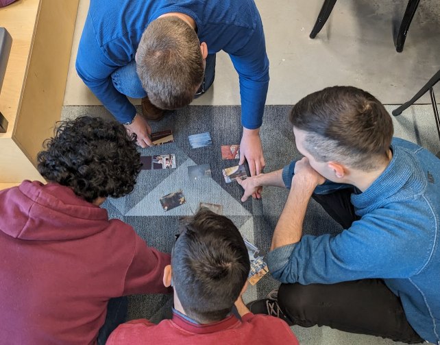 Deelnemers spelen Shut Up N Shop aan tafel