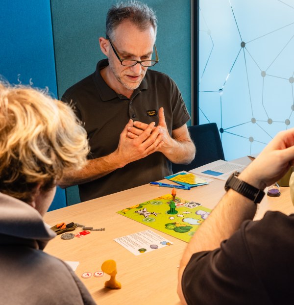 Deelnemers spelen samen aan tafel